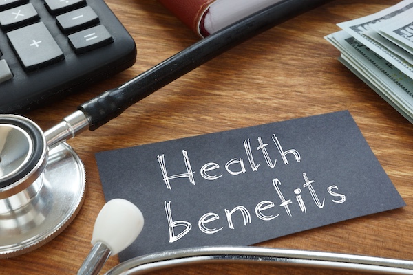 laptop, stethoscope, and money on a desk